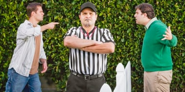 Hispanic referee between arguing neighbors
