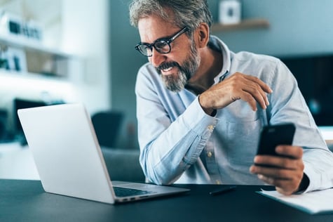 middle aged man looking at laptop