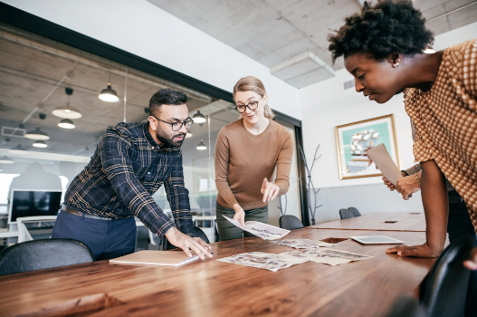 Association manager views home images with a couple at a conference room table Association manager views home images with a couple at a conference room table