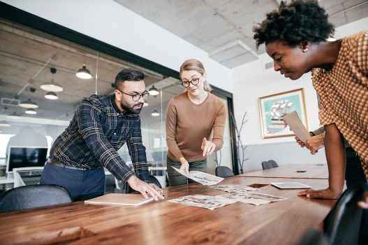 Association manager views home images with a couple at a conference room table