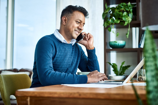 Man speaking on the phone at his office desk Man speaking on the phone at his office desk