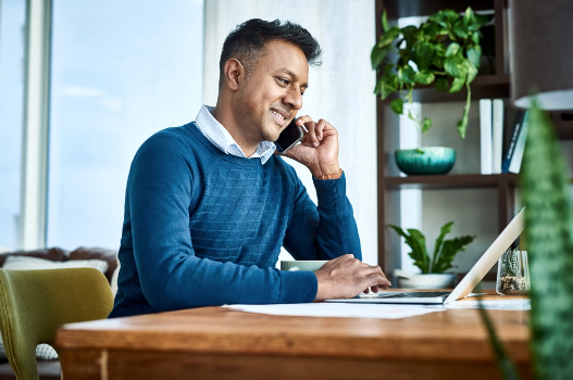 Man speaking on the phone at his office desk